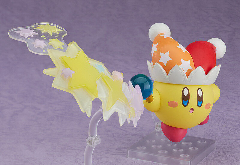 Good Smile Nendoroid Kirby Beam Kirby dynamic action pose swinging star rod with alternate beam effect parts yellow stars trail blue orb red hat orange stars white pom poms on stand purple backdrop Nintendo chibi figure