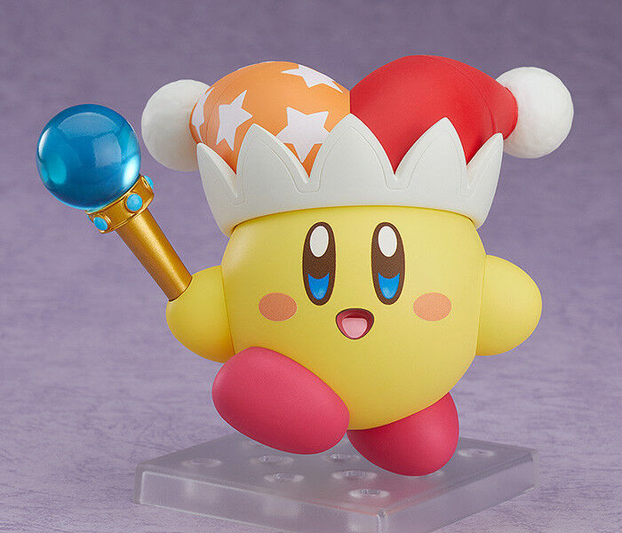 Good Smile Nendoroid Kirby figure on display stand against purple backdrop holding star rod wand with blue orb red hat orange stars white pom poms cheerful eyes pink cheeks yellow body Nintendo Beam Kirby collectible
