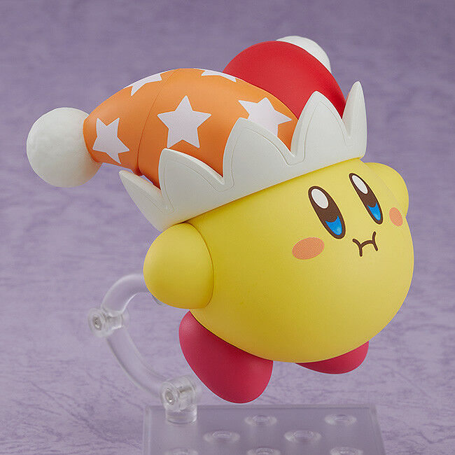 Good Smile Nendoroid Kirby figure surprised open mouth face plate red hat orange stars white pom poms pink cheeks yellow body red feet on clear stand purple background Nintendo chibi Beam Kirby expression collectible